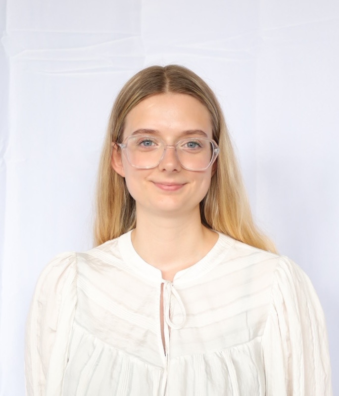 Image depicting the headshot of a young blonde woman with glasses.